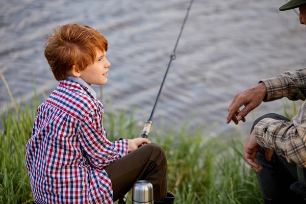 Avô e neto pescando no cais do rio, homem sênior conversando com o menino — Fotografia de Stock