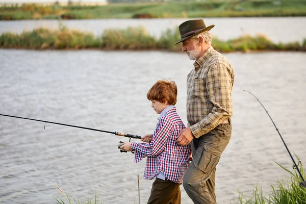 Família, geração, férias de verão e conceito de pessoas. avô e neto pesca — Fotografia de Stock