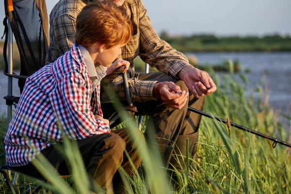 Avô mentoring neto para pescar em tenra idade, vista lateral, na natureza, campo — Fotografia de Stock