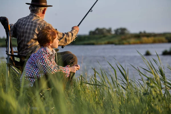 Familj, generation, semester och människor koncept. trevlig farfar och sonson fiske — Stockfoto