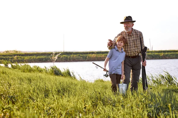 grandfather and grandson going to fish. Little helper fishing. Family Time Together.