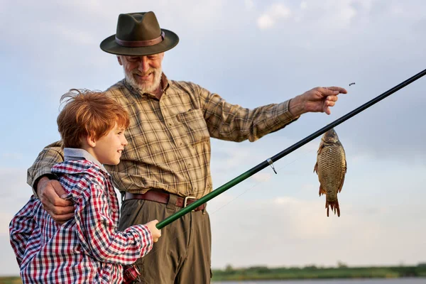 Dia da família. Sortudo e habilidoso. Apanhar peixe com o avô. Pescadores experientes — Fotografia de Stock