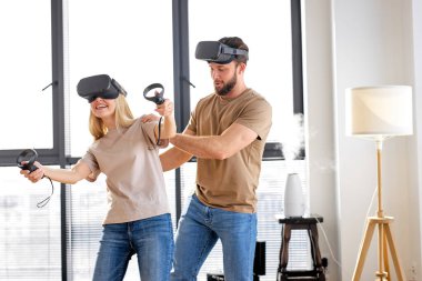 Görsel gerçeklik kavramı, beyaz bir çiftin video oyunu oynamayı öğrenmesi, yan görüş.
