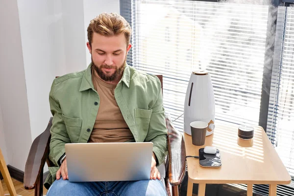 Guapo joven uso de ordenador portátil en casa en relajarse ocio interior actividad — Foto de Stock