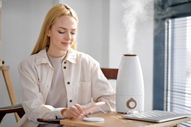 Kadın cep telefonu bataryasını kablosuz şarj cihazıyla dolduruyor, boşluğu kopyala