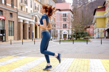 Şehirde yolda koşan bir kadın. Yaşam tarzı sabah koşusu. Fitness ve sağlıklı yaşam tarzı