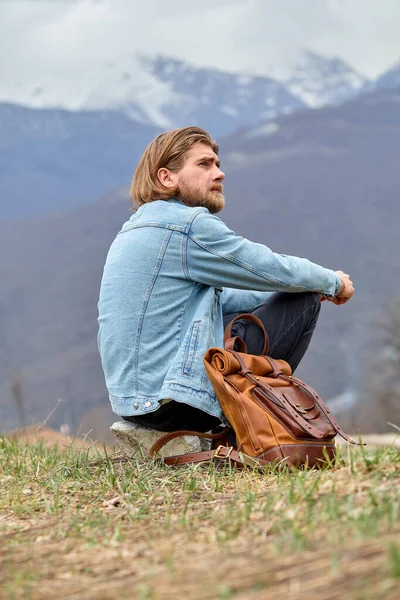 Soñador viajero caucásico macho sentarse solo en la naturaleza, en la contemplación de las montañas —  Fotos de Stock