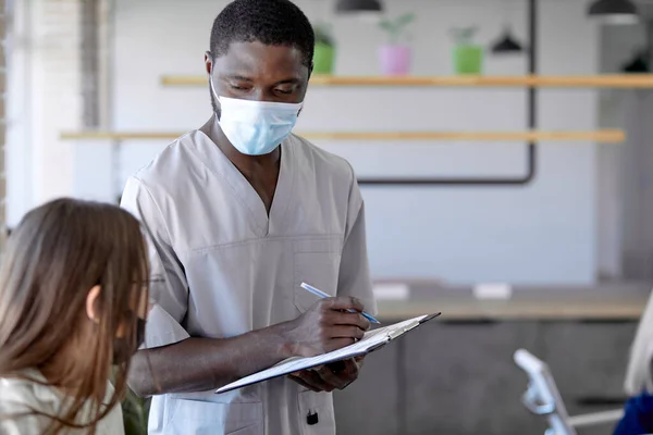 Масова вакцинація. Африканська медсестра - самець веде записи заражених людей за допомогою планшета. — стокове фото