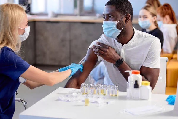 大量予防接種と予防接種。黒人患者を注射する女性看護師 — ストック写真