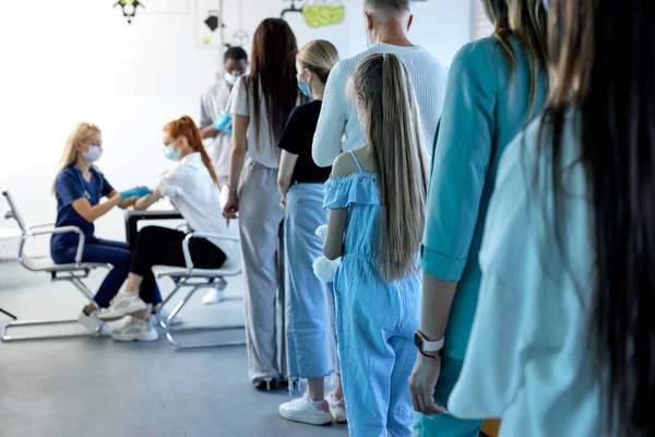 Vista a partir de volta na fila de pessoas pacientes prontos para vacinação em massa no hospital — Fotografia de Stock