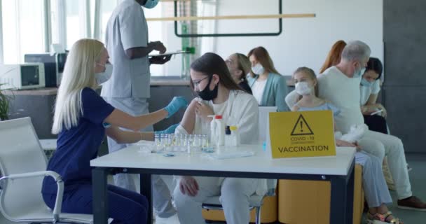 Belle infirmière professionnelle de travailleur médical faisant l'immunisation à l'adolescente — Video