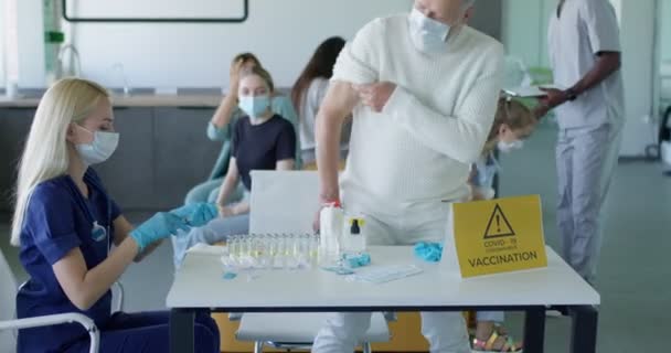 Vaccination de la personne âgée au cabinet des médecins. Seringue avec vaccin pour covide-19 — Video