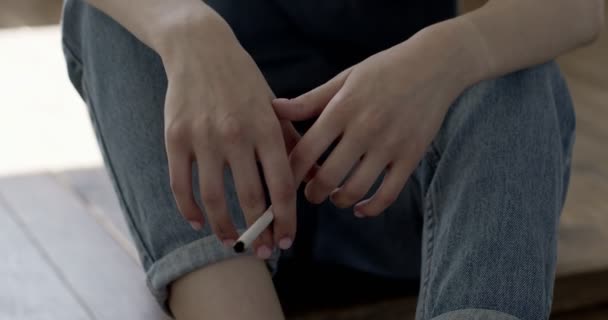 Kadın elinin yakın plan fotoğrafı, yerde oturmuş sigara içen yalnız üzgün, sorun stresi.. — Stok video