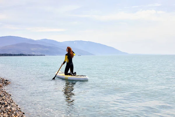 SUP Stand up paddle board. Rückansicht einer fitten Frau, die auf schöner ruhiger See segelt — Stockfoto