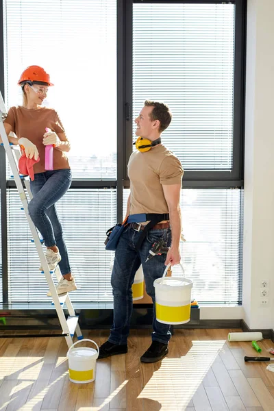 Pleasant man and woman cleaning house after renovation, man help wife, use stepladder — Fotografia de Stock