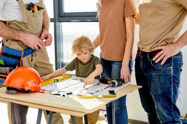 Child boy study blueprint with interest, parents having talk about home renovation — Fotografia de Stock