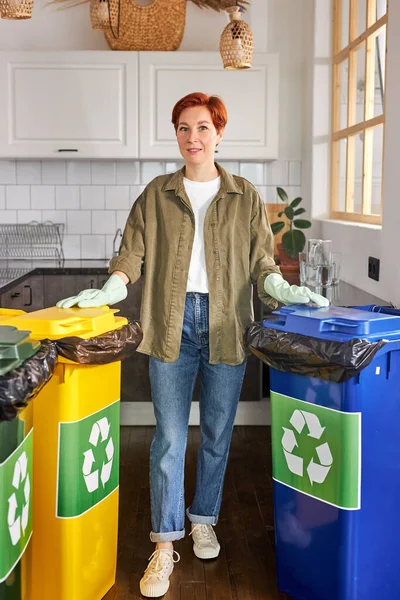 Ativista do sexo feminino cuidando do meio ambiente durante a triagem de resíduos para uma lixeira adequada — Fotografia de Stock