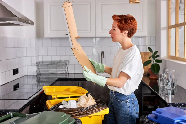 Gündelik giysiler içinde genç bir kadın temizlik yaparken çöpleri ayırıyor. Temizlik kavramı — Stok fotoğraf