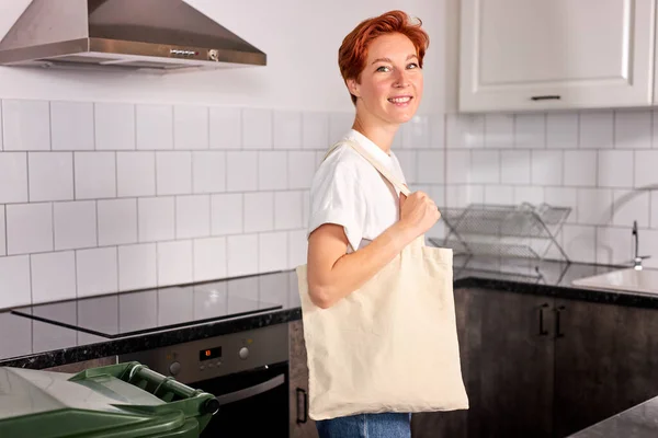 young woman using cotton reusable tote bag, using eco shopper instead of plastic bag