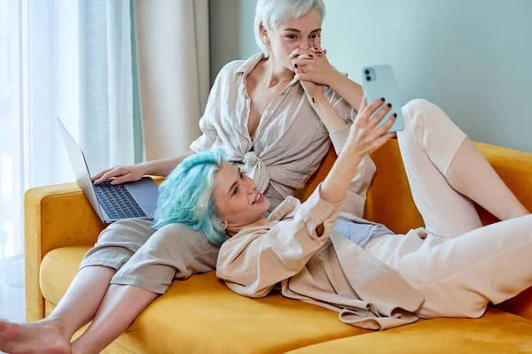 LGBT couple lesbien meilleures copines se reposer à la maison sur le canapé, prendre des photos sur smartphone — Photo