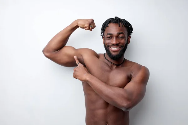 Afro jovem ajuste atlético homem mostrando bíceps, isolado no branco estúdio fundo — Fotografia de Stock