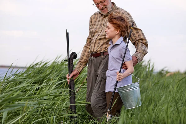 Friendly caucasian multi-generation family fishing together from riverside at sunset — Stockfoto