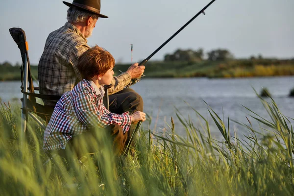 Granddad with grandson fishing together, teaching little young boy to be fisherman — Stockfoto