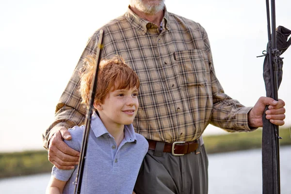 Abuelo y nieto van a pescar. Un poco de pesca ayudante. Tiempo en familia juntos. — Foto de Stock