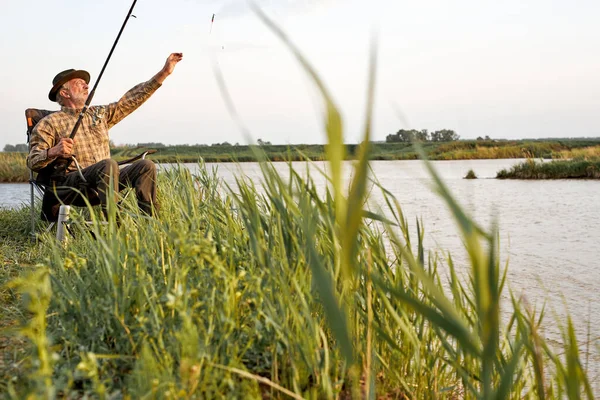 Senior man fishing on lake. Fish on hook. Master baiter. Gone fishing. Summer vacation. — Fotografia de Stock