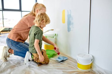 Arkadaş canlısı anne ve oğul duvar boyuyor ve eğleniyor, Apartman dairesinde Tamir