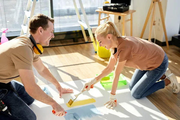 Side view on young couple enjoying drawing at weekends, on floor, love and family concept — Fotografia de Stock