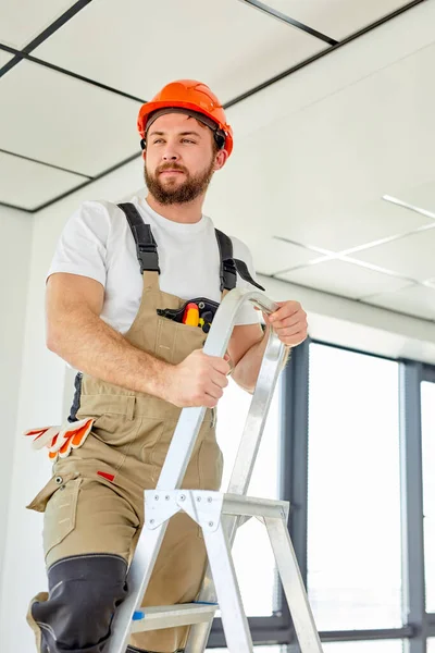 Contratante reparador profissional confiante trabalhando no painel de teto aéreo — Fotografia de Stock