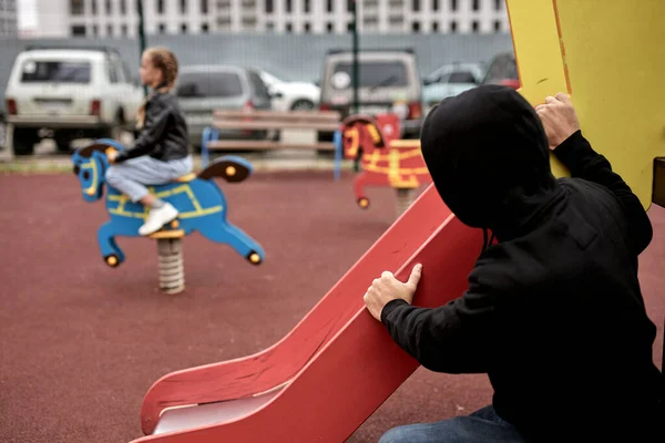 恐ろしい脅迫小児性愛者は子供の頃遊び場で楽しみながら — ストック写真