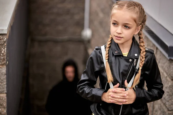 Gevaarlijke man volgt meisje op straat. Ontvoering van kinderen. Mensenhandel — Stockfoto