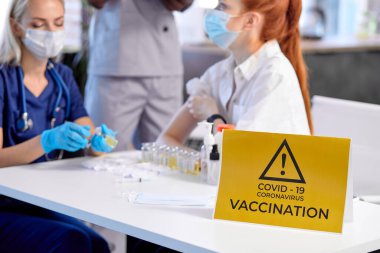 Kadın doktor hastayı koronavirüs aşısı için hazırlıyor. Tıp konsepti.