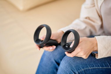 Evdeki oturma odasında video oyunu oynayan tanınmayan kadın elleri.