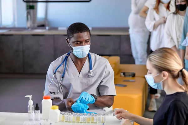 Koronavirüse karşı aşı. Erkek siyah doktor grip aşısını enjekte etmeye hazırlanıyor. — Stok fotoğraf