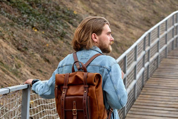 Visão traseira em hipster pensativo macho andando na ponte no campo sozinho — Fotografia de Stock