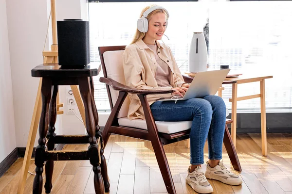 Привлекательная женщина учится или работает на ноутбуке, сидя дома, с увлажнителем — стоковое фото