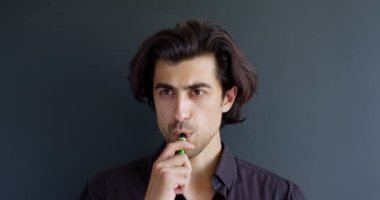 Elektronik sigara içen adam siyah, alternatif nikotin ısıtma ürünüyle izole edilmiş.