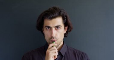 Elektronik sigara içen adam siyah, alternatif nikotin ısıtma ürünüyle izole edilmiş.