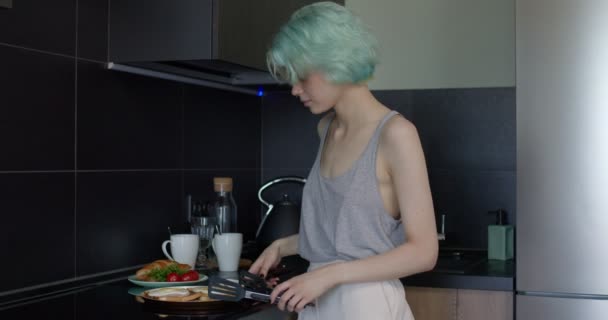 İki lezbiyen bayan arkadaş mutfakta kahvaltı hazırlıyor, öpüşüyor ve sarılıyorlar. insan yaşam tarzı — Stok video