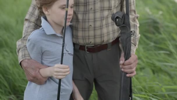 Dziadek z wnukiem rozmawia przed łowieniem ryb na jeziorze — Wideo stockowe