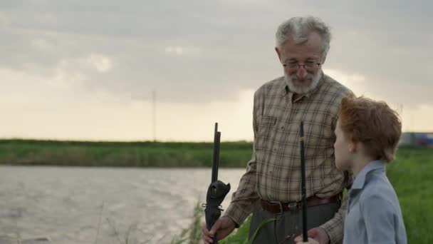 Niño con abuelo volar pesca al aire libre sobre fondo del río. Pesca — Vídeos de Stock