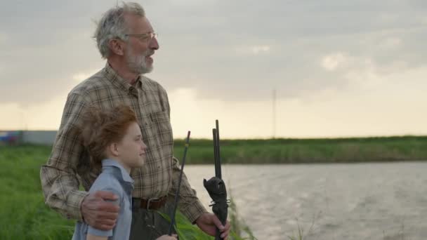 Καυκάσιος με τον παππού να πετάει για ψάρεμα πάνω από το ποτάμι. Αλιεία — Αρχείο Βίντεο