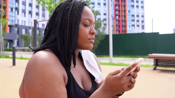 Afričanky americká žena ve sportovním oblečení sedět relaxační, s odpočinkem po sportu — Stock video
