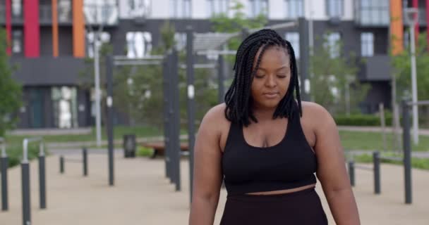Gordo, plus size Africano americano jovem mulher em sportswear olhando para a câmera — Vídeo de Stock
