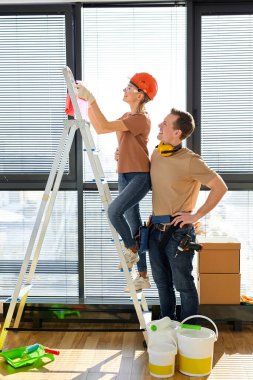 Tadilattan sonra evi temizleyen duyarlı erkek ve kadın, adam karısına yardım ediyor, merdiven kullanıyor