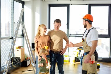 Kendine güveni tam bir tamirci müşterilerin ailesiyle tokalaşmak için elini uzatıyor.