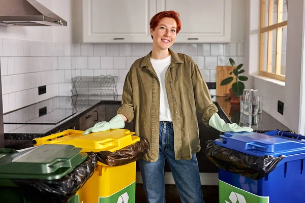 Person som sorterar skräp. Rödhårig hona separat avfall och kasta skräp i återvinningskärl — Stockfoto